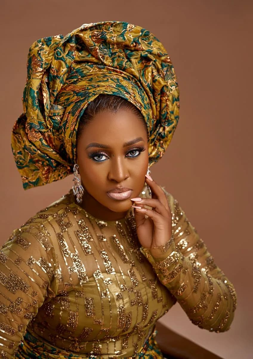 Sefiya Diejomaoh in a gold sequinned dress and patterned gele